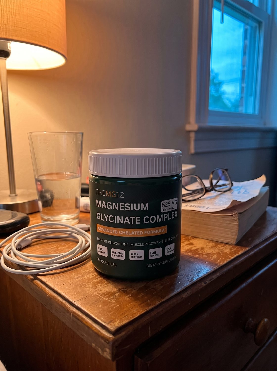 The jar on a nightstand beside a glass of water and reading glasses